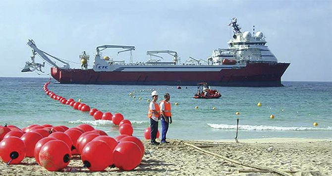 Un barco arrastra una línea con boyas indicando la ruta del cable submarino / EFE