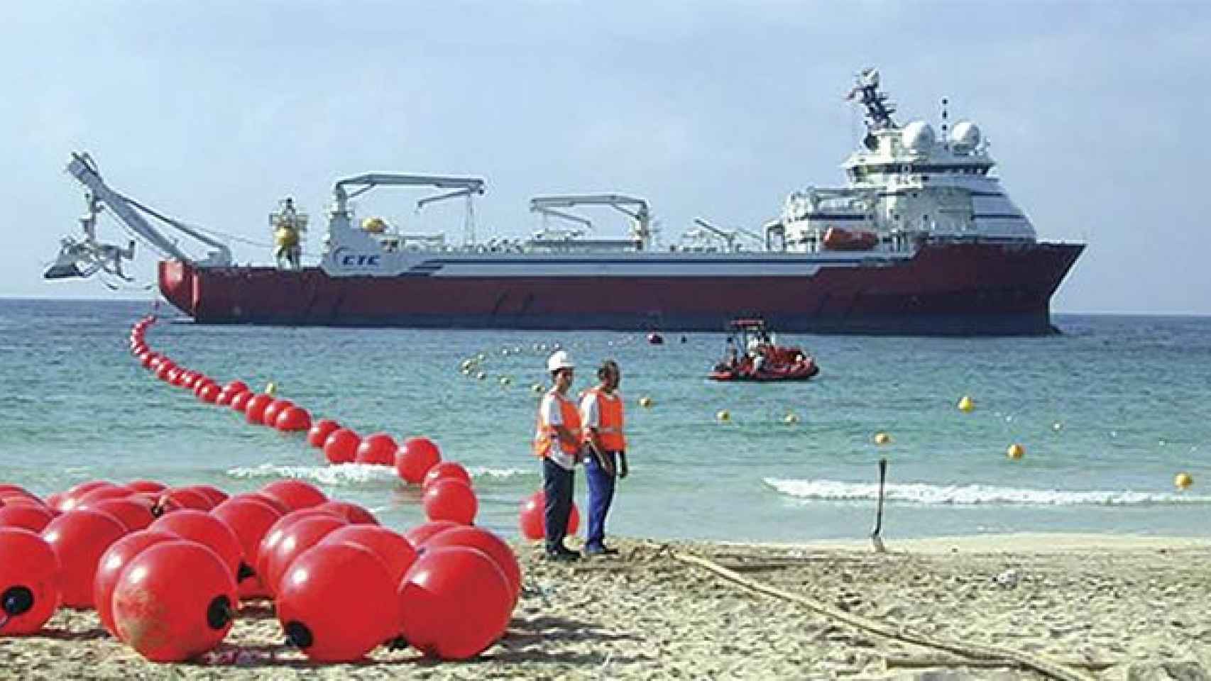 Un barco arrastra una línea con boyas indicando la ruta del cable submarino / EFE