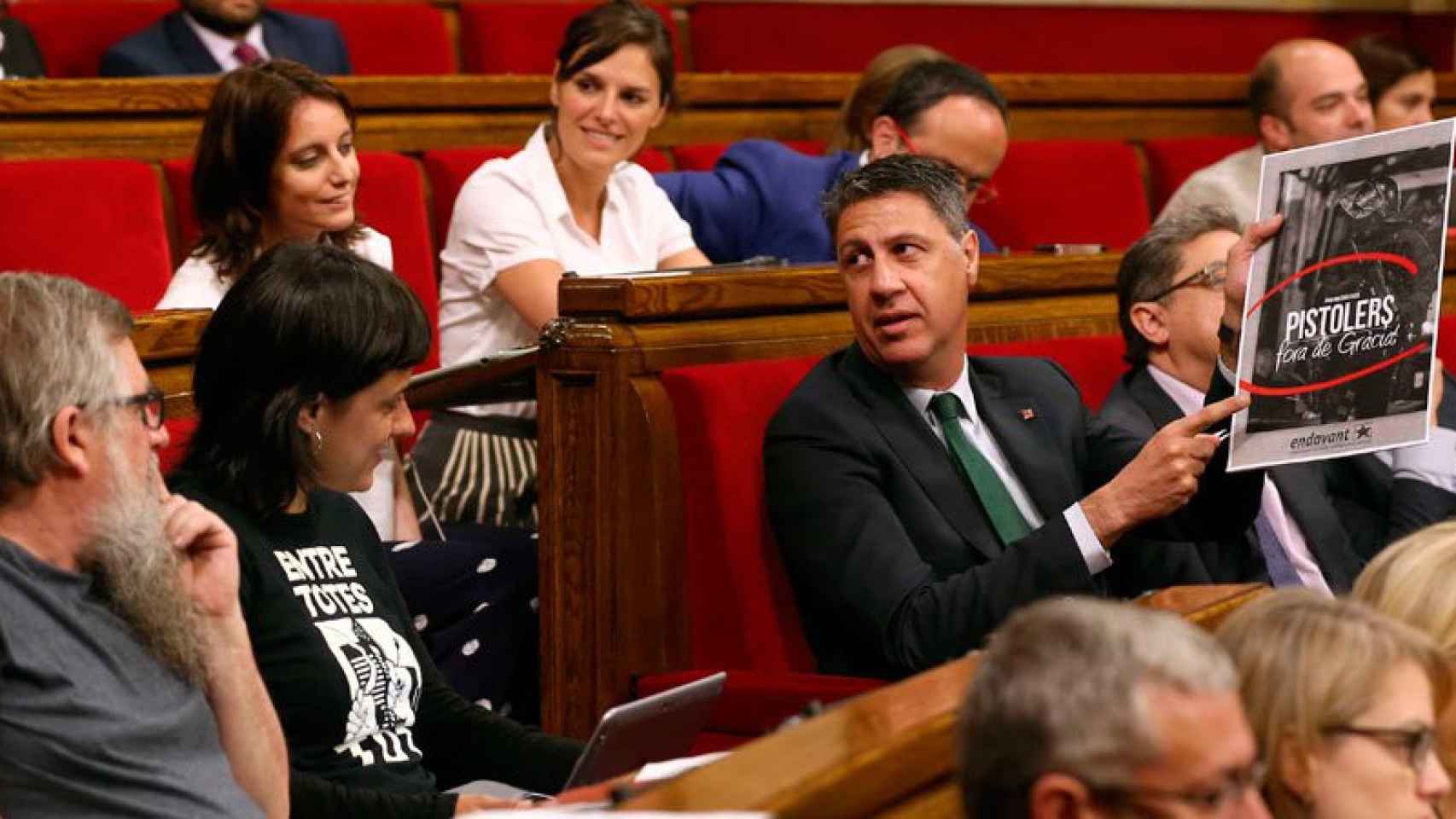 El lider parlamentario del PPC, Xavier García Albiol, se dirige a los diputados de la CUP (i) mostrando un cartel editado por Endavant, un sector de la CUP.