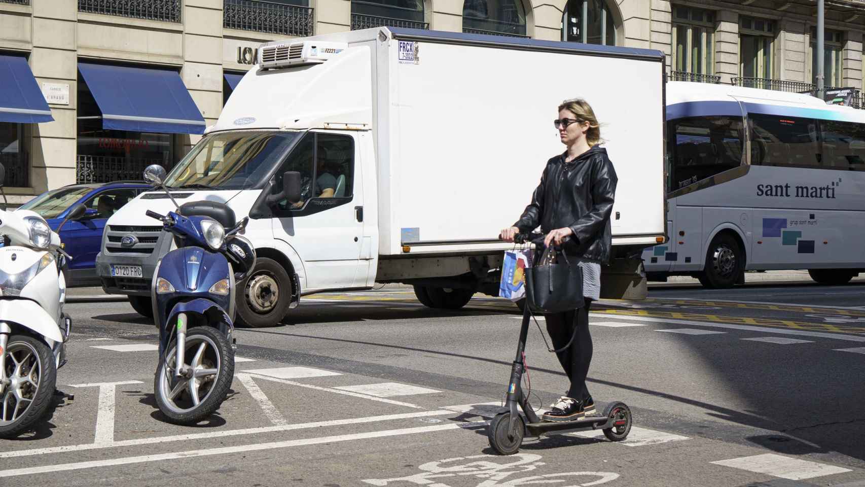 Una mujer cruza un paso de peatones en un patinete eléctrico / PABLO MIRANZO (CG)