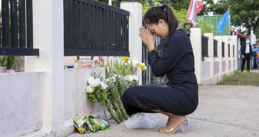 Una mujer reza frente a la entrada del centro infantil Uthai Suwan un día después del tiroteo mortal que acabó con la vida de 38 personas / EUROPA PRESS