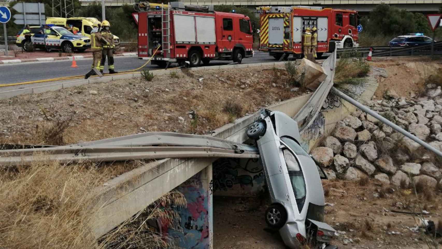 El vehículo tras caer por un puente de Coma-ruga / BOMBERS