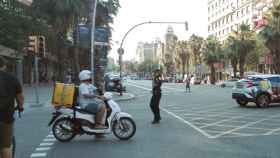 Una agente de policía dirige el tráfico junto a un semáforo apagado durante el corte de luz del 31 de julio en el cruce Casp y Marina de Barcelona / CG