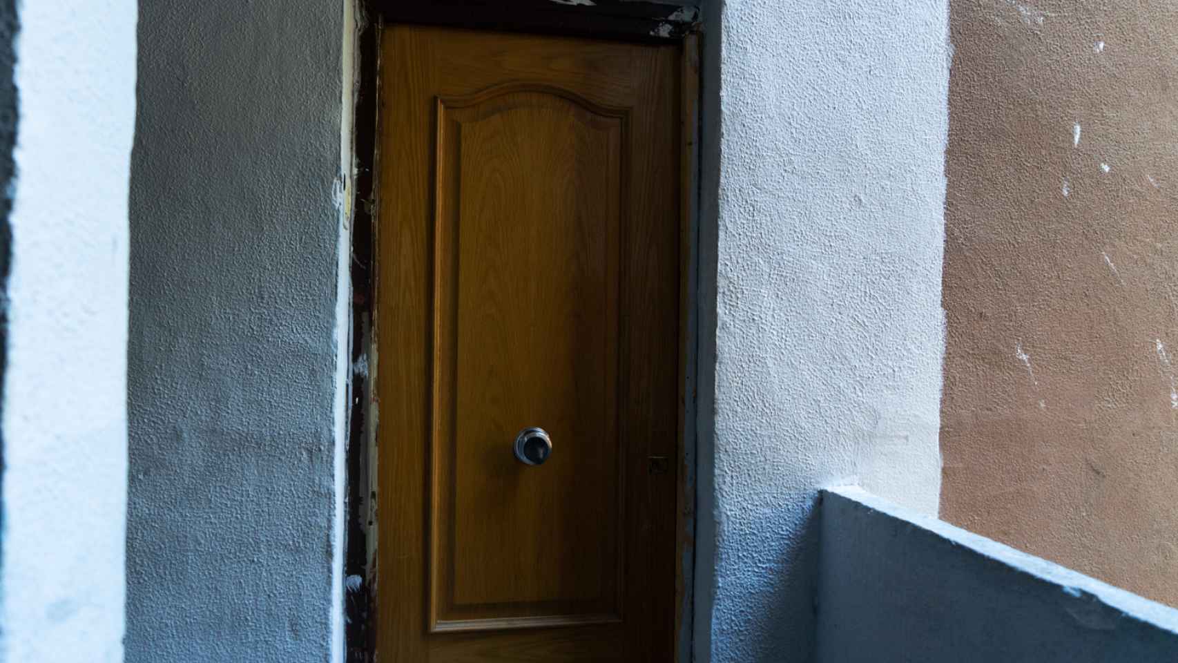 La puerta de un piso okupado en un bloque del Besòs, en Barcelona / LUIS MIGUEL AÑÓN (CG)