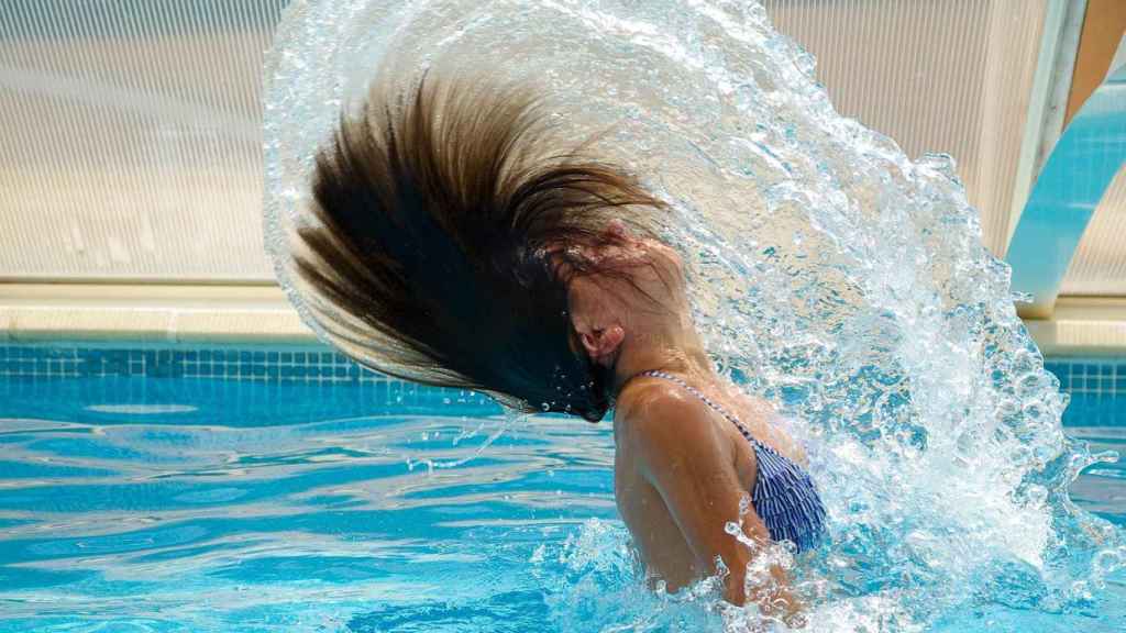 Una mujer en una piscina / PIXABAY