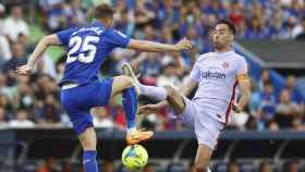 Busquets, disputando el balón contra Mayoral, durante el empate entre Getafe y Barça / EFE