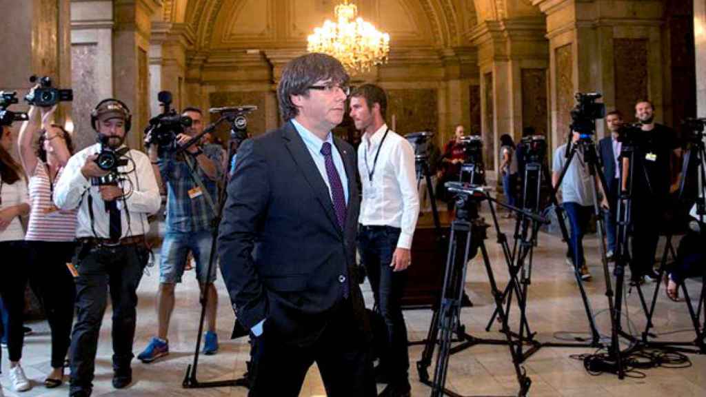 El presidente Carles Puigdemont, rodeado de trípodes de cámaras en los pasillos del Parlament durante el pleno de desconexión / EFE