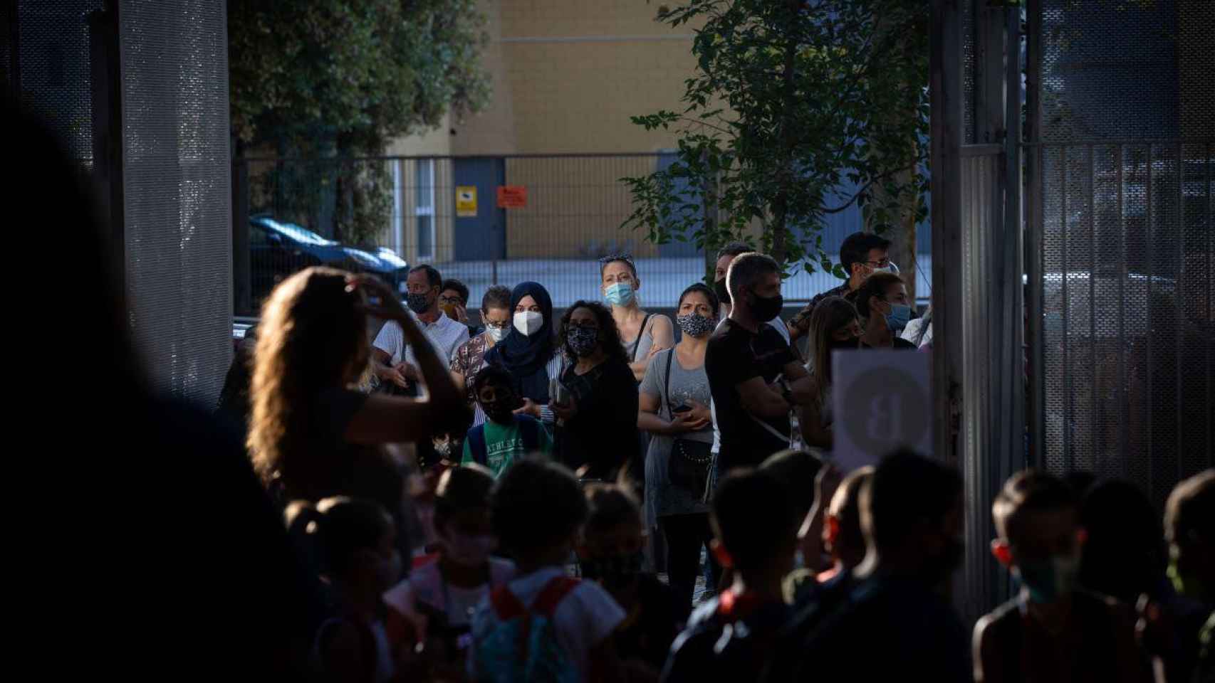 Padres y alumnos protegidos con mascarillas por el coronavirus a las puertas de un colegio / EP