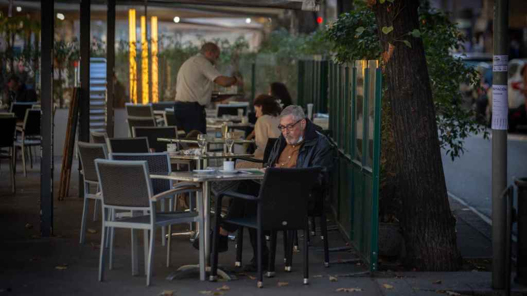 Un hombre lee en la terraza de un bar / EP