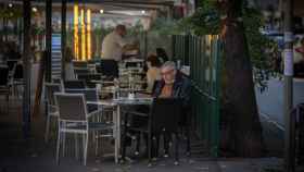 Un hombre lee en la terraza de un bar / EP