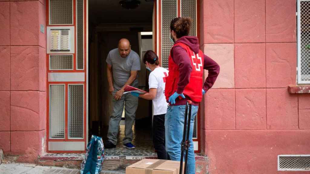 Un trabajador de Cruz Roja reparte alimentos durante las restricciones por la pandemia / EUROPAPRESS