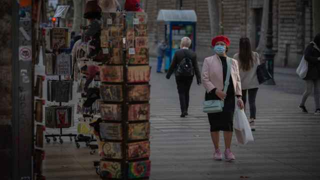 Una mujer frente a una tienda de artículos turísticos en Barcelona / DAVID ZORRAKINO - EUROPA PRESS