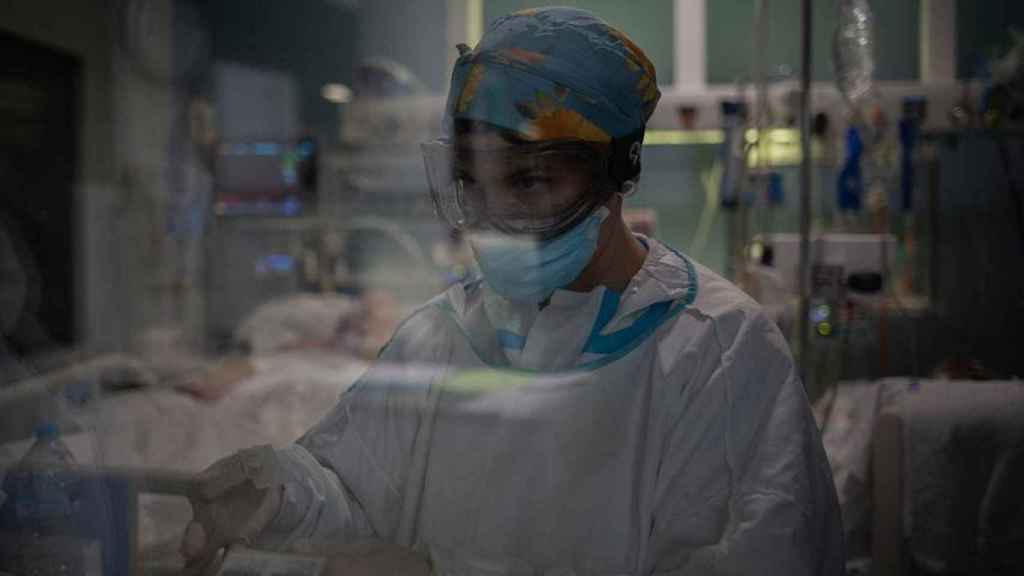 Una trabajadora sanitaria atiende a los pacientes ingresados por Covid en la uci de un hospital de Cataluña / David Zorrakino (EP)