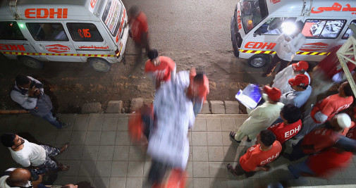 Los equipos de rescate transportan los cuerpos de las víctimas del incendio de un autobús a una morgue en Karachi, Pakistán / EFE