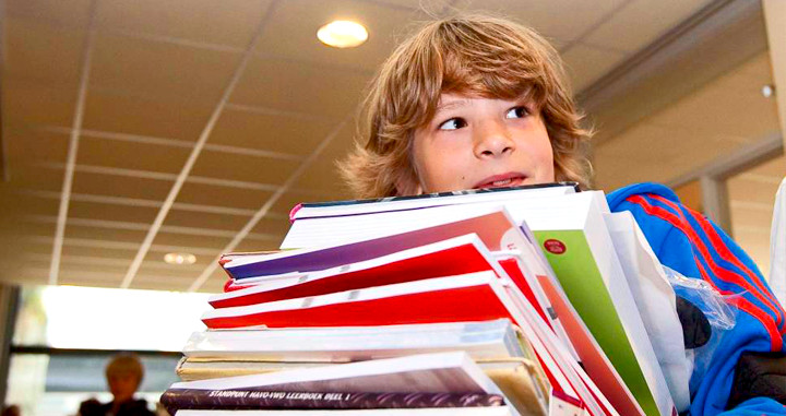 Un alumno carga con un montón de libros en la 'vuelta al cole' / EFE