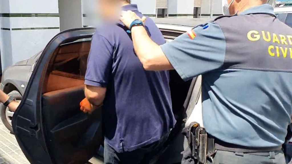 Un agente acompaña a un detenido al coche / GUARDIA CIVIL