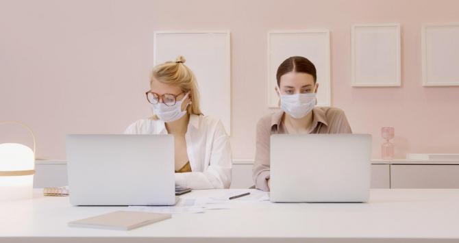 Dos mujeres trabajan en la oficina con mascarilla / PEXELS