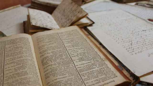 Mesa de trabajo de un traductor antiguo con diccionario en primer término. Imagen del artículo 'La sombra del camaleón'
