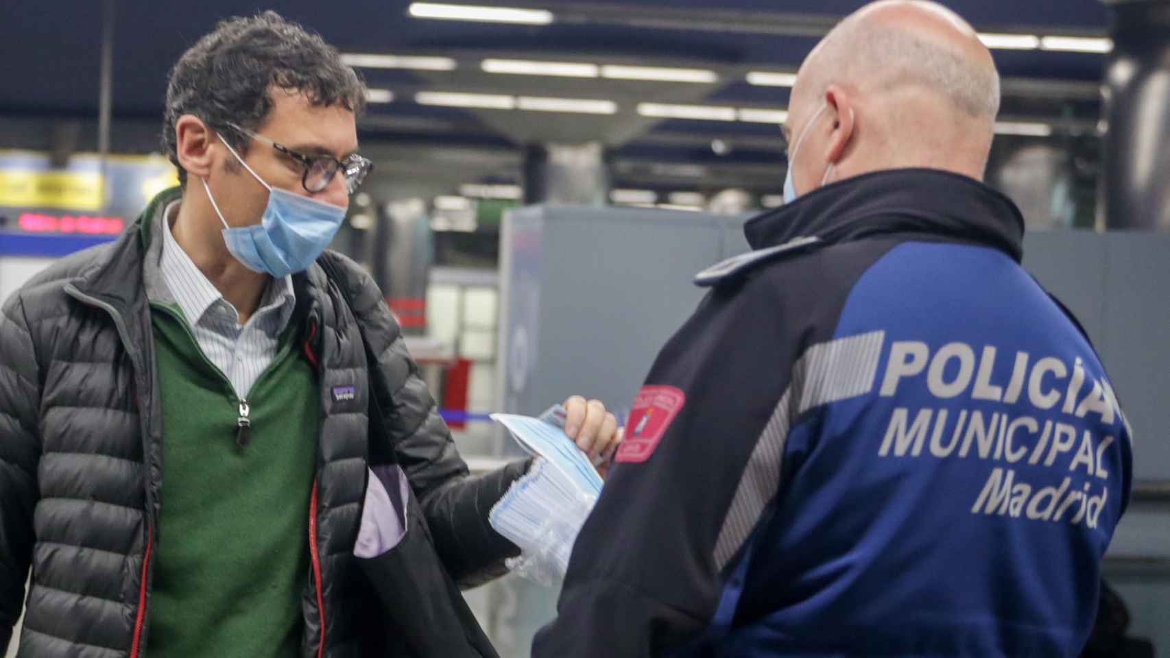 Un policía reparte mascarillas en una estación de Metro / EP