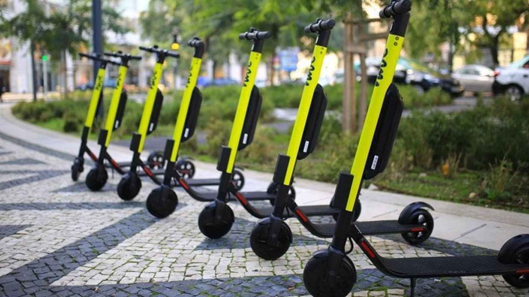 Varios patinetes eléctricos en una acera / DAIMLER