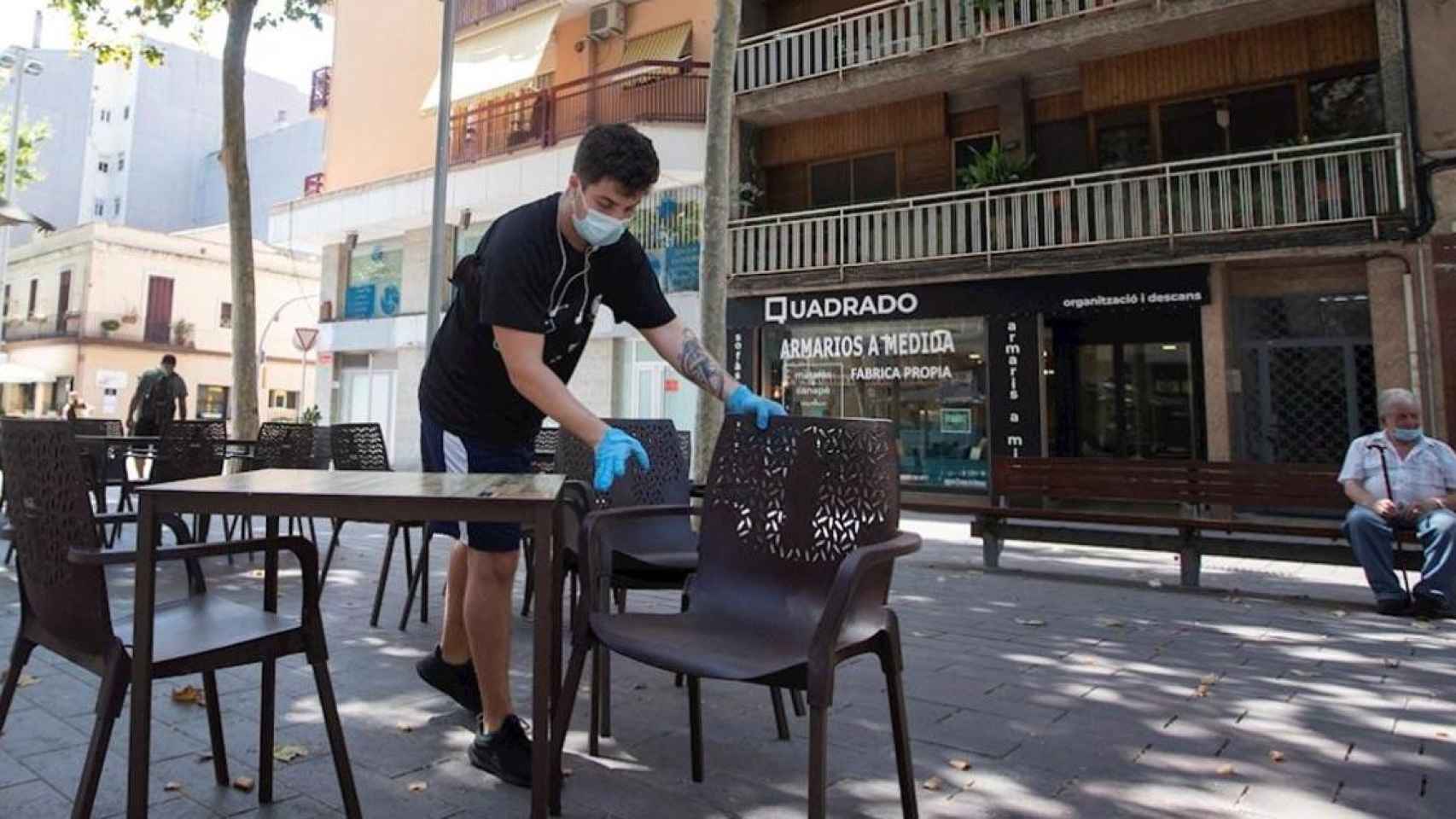 Empleado de un bar limpia la terraza / EFE