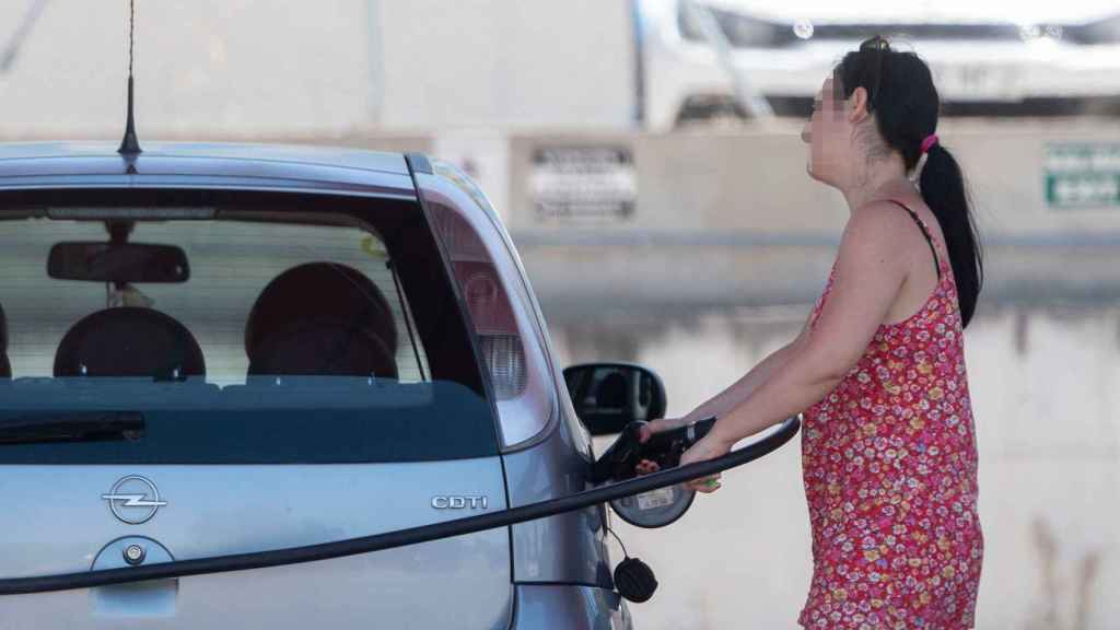 Una pasajera reposta en una gasolinera a la altura de Rivas, durante la primera operación salida del verano de 2022 / Alberto Ortega - EUROPA PRESS