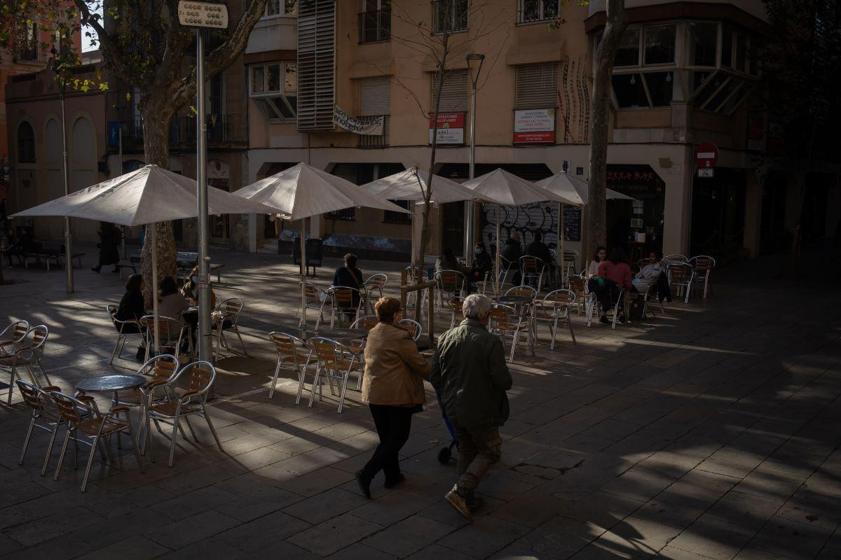 Dos personas pasean delante de una terraza semivacía por las restricciones a la resturación / EP