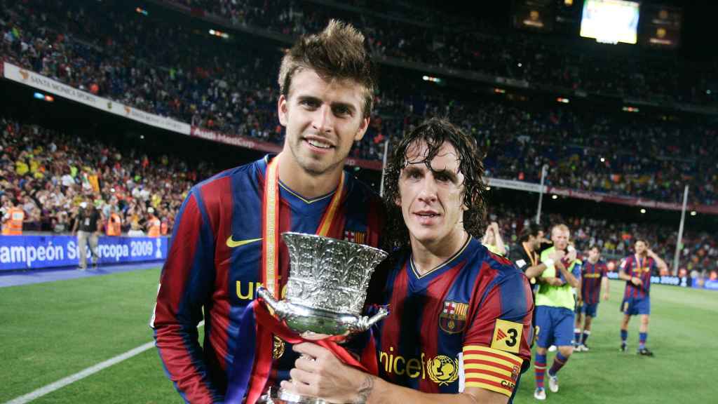 Gerard Piqué y Carles Puyol, sujetando el título de la Supercopa de España / FCB