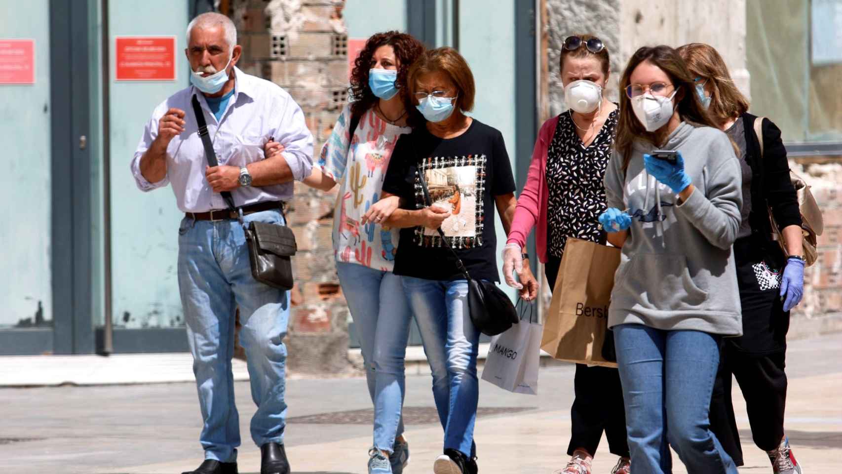 Un grupo de personas haciendo uso de la mascarilla obligatoria pero con poca distancia social / EP