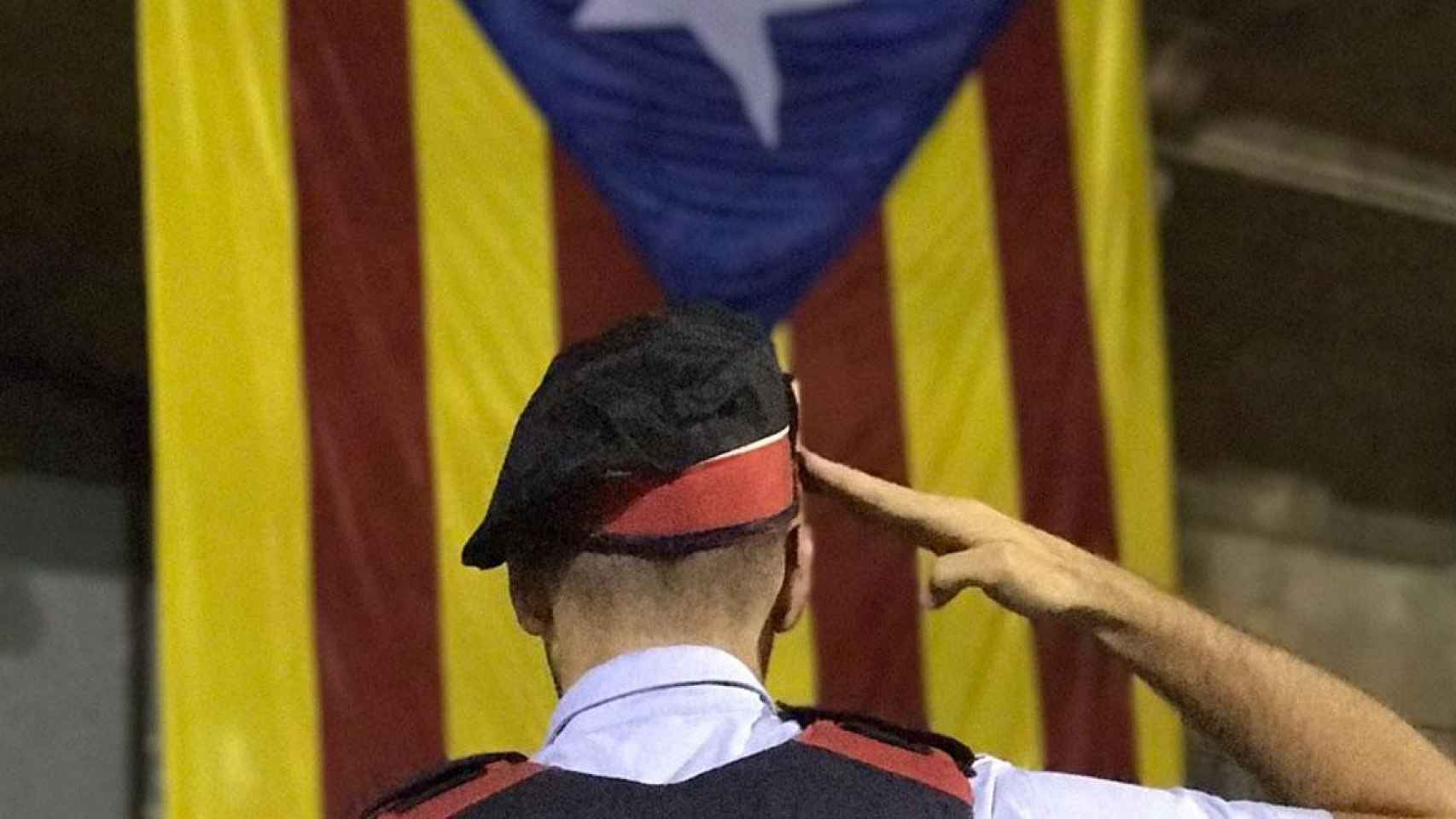 Un mosso independentista como Albert Donaire se cuadra ante una estelada / EFE