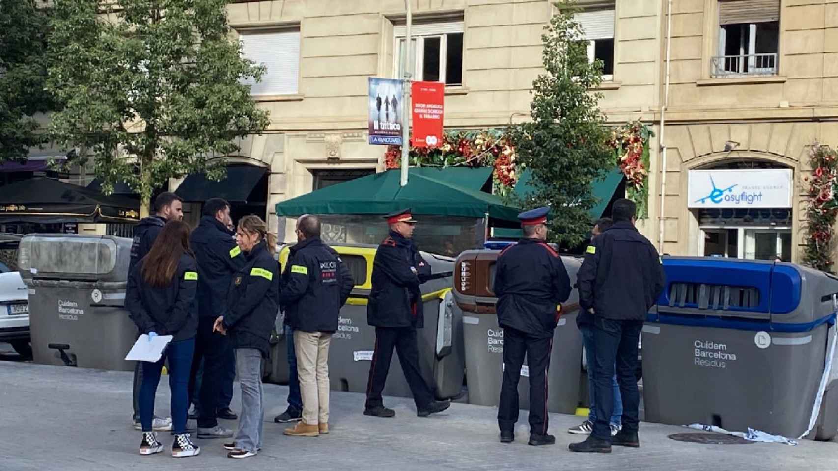 Agentes de los Mossos d'Esquadra inspeccionan los contenedores del chaflán en el que ha aparecido un torso humano en el interior de una maleta / SARA CID - CRÓNICA GLOBAL