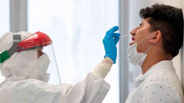 Un sanitario de los ambulatorios catalanes recogiendo una muestra de un paciente para hacer un test PCR de detección del virus / EFE