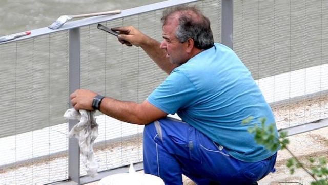 Un hombre repara una valla pública, imagen de las contrataciones registradas en este agosto en las que sólo el 5% de los contratos son indefinidos a tiempo completo / ME