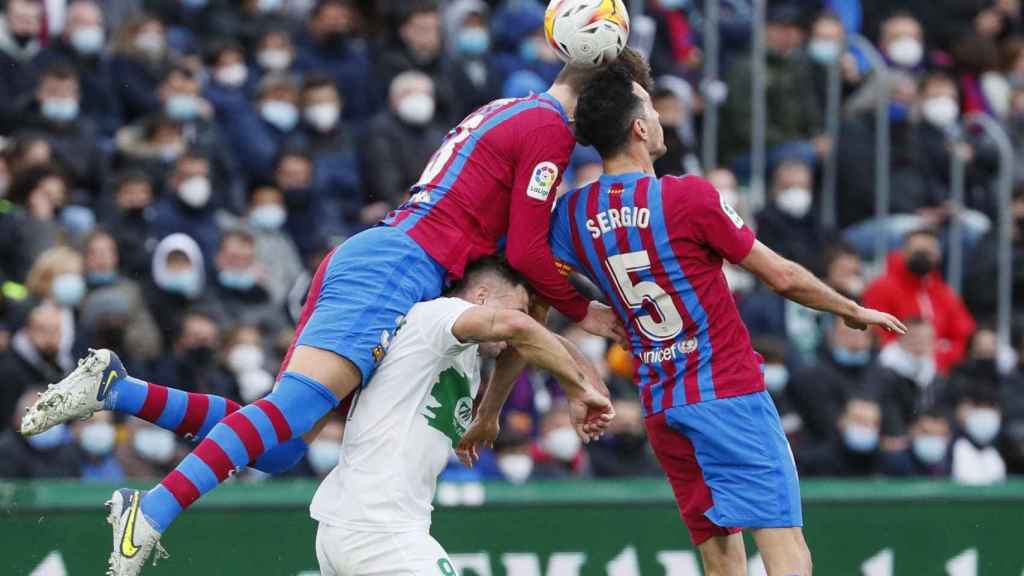 Piqué y Sergio Busquets pugnan por un balón con Lucas Boyé / EFE