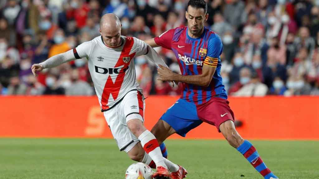 Sergio Busquets pugna por el control del balón con Isi, en Vallecas / EFE