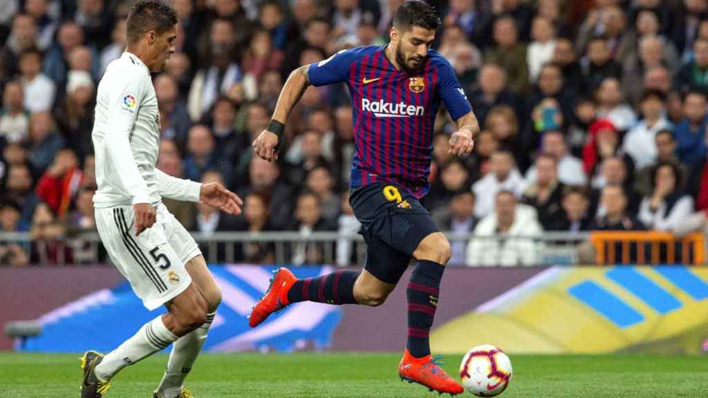 Luis Suárez supera a Varane durante el clásico liguero / EFE