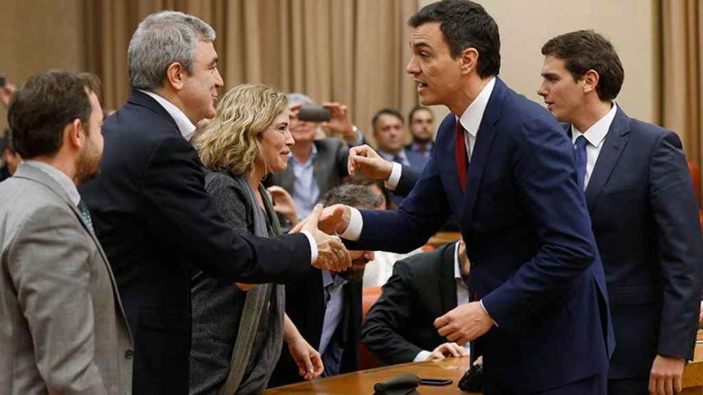 Pedro Sánchez (D) saluda a Luis Garicano, el 'cerebro' económico de Ciudadanos, tras la firma del acuerdo de gobierno.