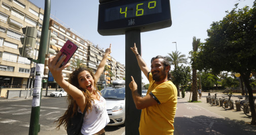 Unas personas se fotografían junto a un termómetro que marcaba 46 grados en el centro de Córdoba / EFE - Salas