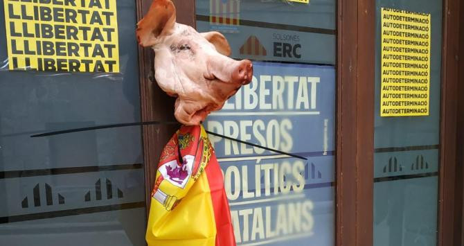 La cabeza de cerdo y la bandera atadas a las puertas de la sede / TWITTER