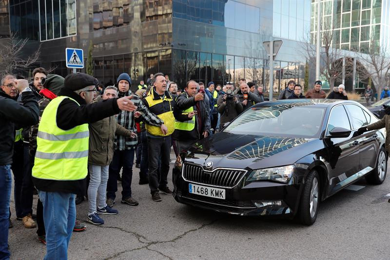 Un grupo de taxistas increpa al conductor de un vehículo VTC a las puertas de Ifema / EFE