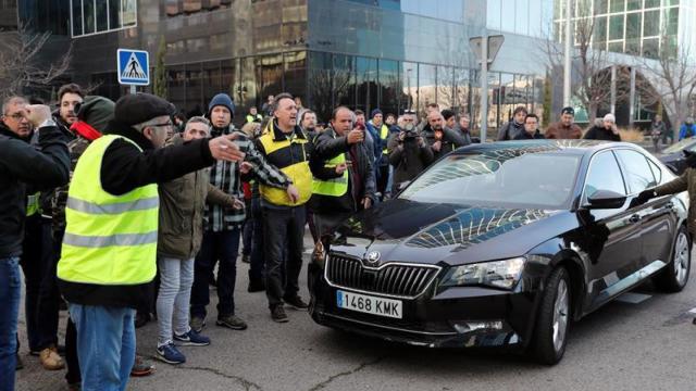 Un grupo de taxistas increpa al conductor de un vehículo VTC a las puertas de Ifema / EFE