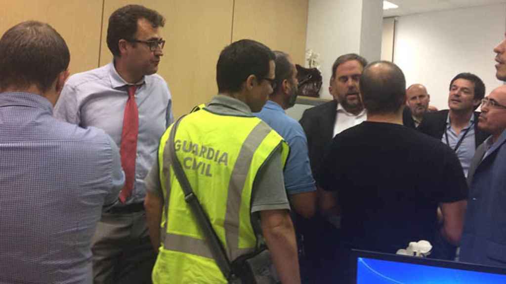 El secretario general de Hacienda, Lluís Salvadó, en el momento de su detención junto a un agente de la Guardia Civil y el vicepresidente Oriol Junqueras / CG