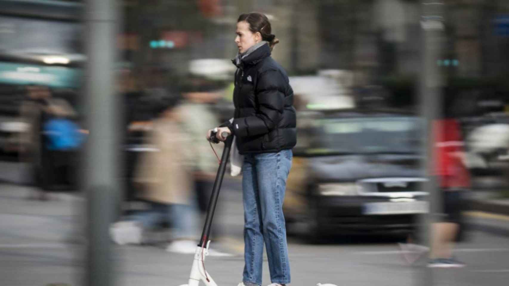 Una mujer en patinete eléctrico / EP