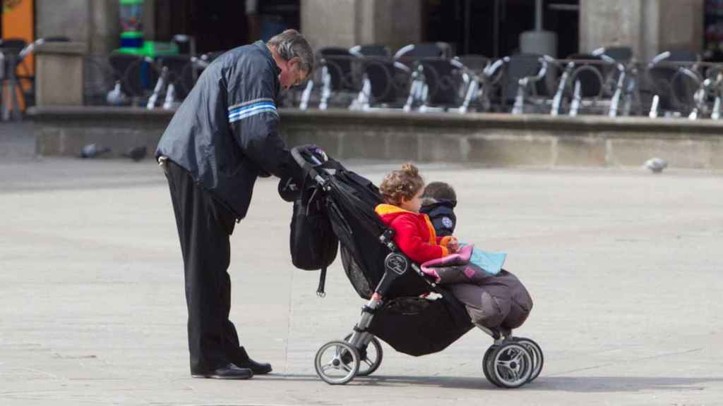 Una persona mayor pasea a sus nietos / EFE