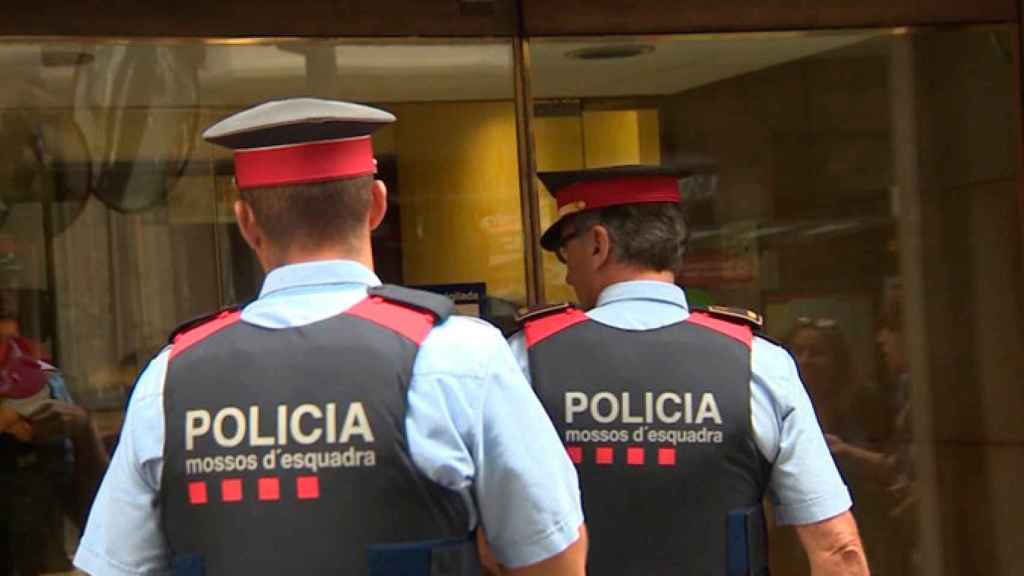 Imagen de dos agentes de los Mossos d'Esquadra entrando en un edificio público / CG