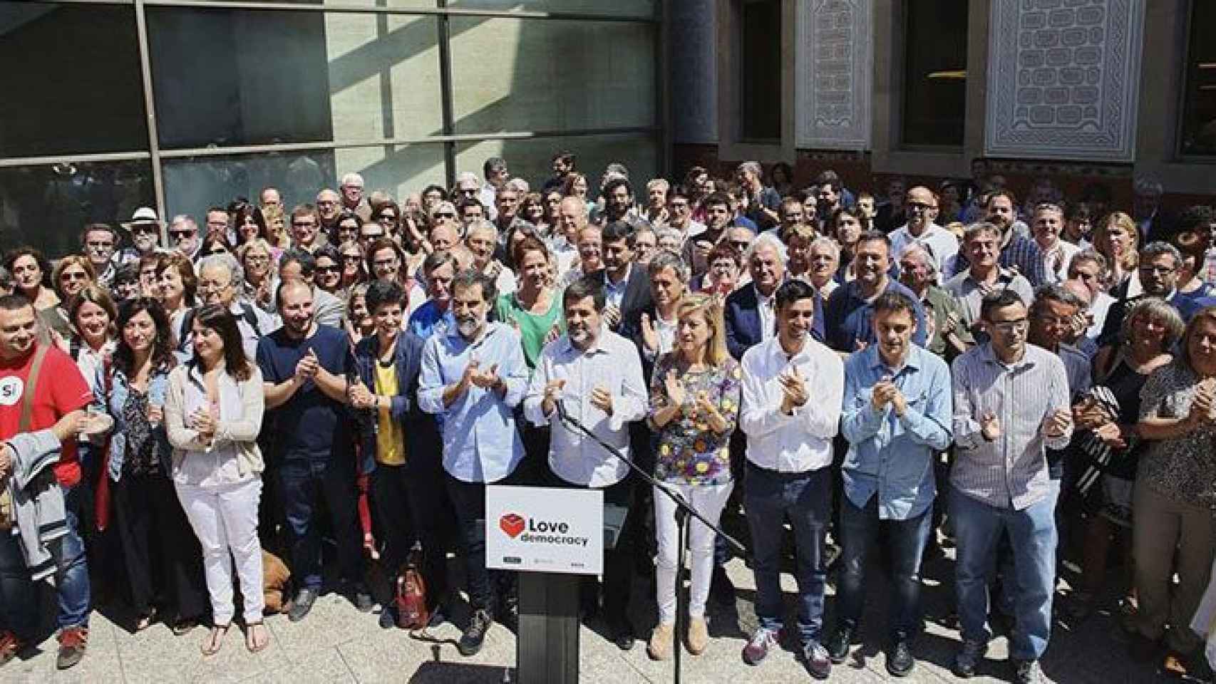 La presidenta de la Asociación de Municipios per la Independència (AMI), Neus Lloveras, el presidente de la Asamblea Nacional Catalana (ANC), Jordi Sánchez, y el presidente de Omnium Cultural, Jordi Cuixart, se fotografían con 150 cargos de las tres entid