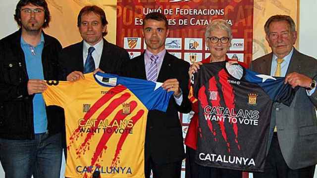 El secretario de Deporte de la Generalidad, Ivan Tibau, junto a la presidenta de Òmnium, Muriel Casals con las camisetas de las selección catalana