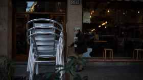 Un hombre pasa por delante de un restaurante con la terraza cerrada por las restricciones del Govern / EP