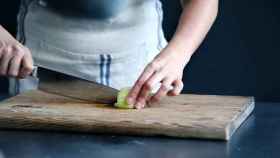 Persona cortando verduras en la cocina / UNSPLASH