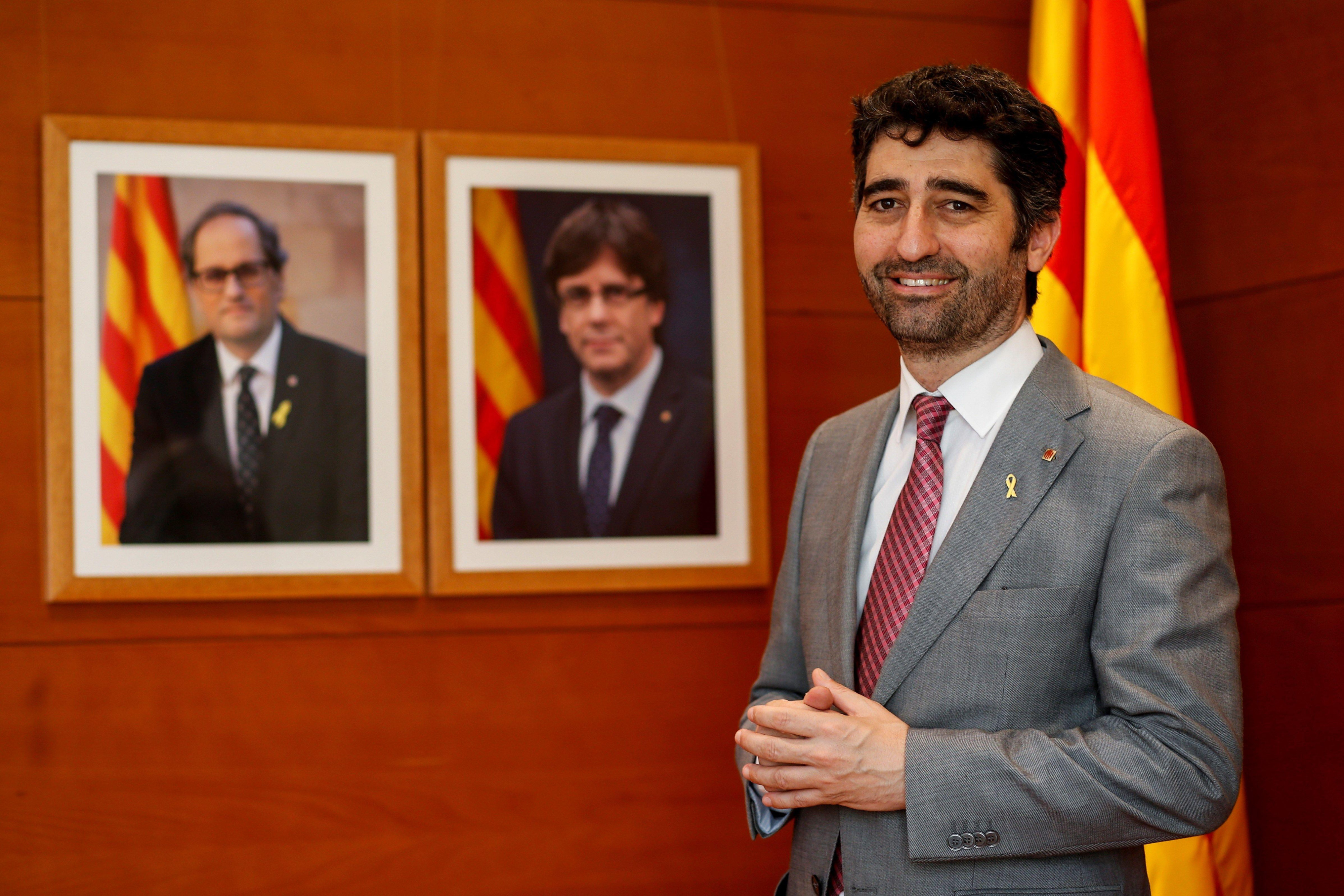 El vicepresidente de la Generalitat Jordi Puigneró (JxCat), junto a los retratos de Quim Torra y Carles Puigdemont / EFE